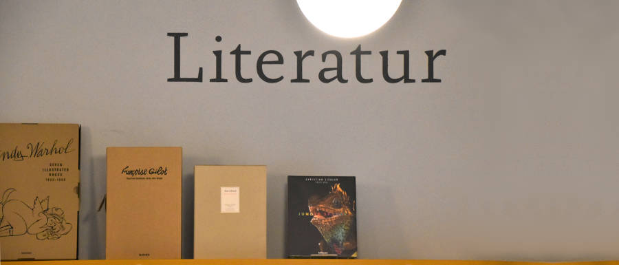 Aufschrift "Literatur" an der Wand. Mehrere Bücher auf Regal. © Robin Menges