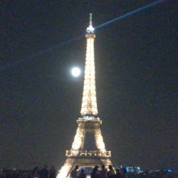 Eiffelturm in der Nacht vor Vollmond. Im Vordergrund sind Menschen zu sehen. © Robin Menges