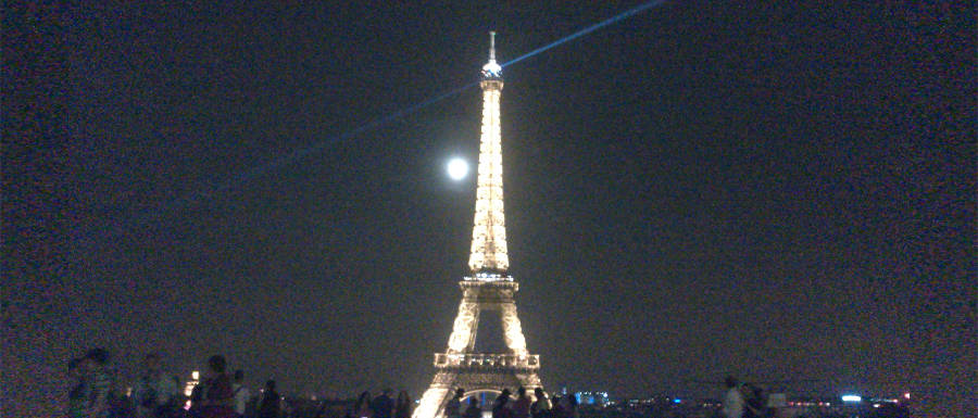 Eiffelturm in der Nacht vor Vollmond. Im Vordergrund sind Menschen zu sehen. © Robin Menges