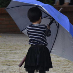 Kind mit großem blauen Regenschirm © Alexandra Menges