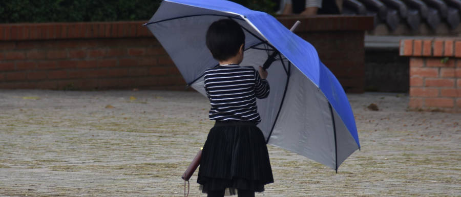 Kind mit großem blauen Regenschirm © Alexandra Menges