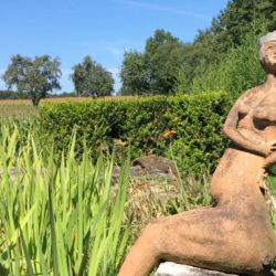 Skulptur einer nackten Frau, umgeben von Natur, an einem See © Robin Menges