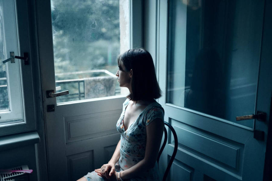 Frau schaut aus dem Fenster / Masha Raymers/Pexels